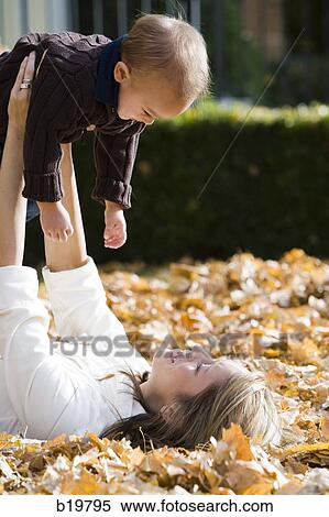 mother and baby playing in fallen leaves View Large Photo Image Stock Photography - mother and baby playing in fallen leaves. Fotosearch