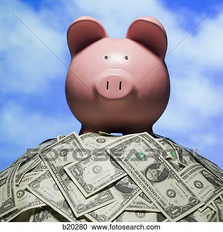piggy bank on a pile of dollars View Large Photo Image Stock Image - piggy bank on a pile of dollars. Fotosearch