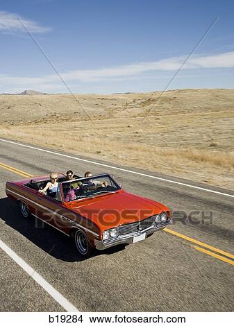 red car driving down the road View Large Photo Image Picture - red car driving down the road. Fotosearch