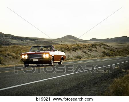 red car driving down the road View Large Photo Image Stock Image - red car driving down the road. Fotosearch