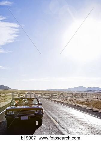 red car driving down the road View Large Photo Image Stock Photo - red car driving down the road. Fotosearch