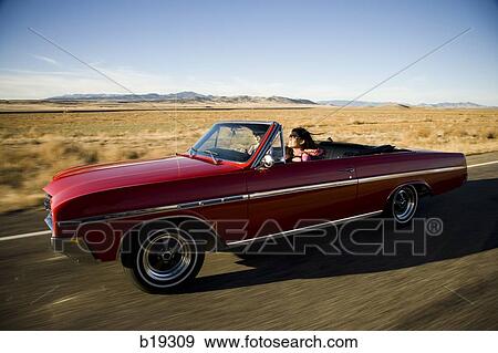 red car driving down the road View Large Photo Image Stock Photo - red car driving down the road. Fotosearch