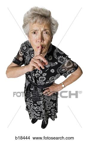 Senior woman shushing camera. View Large Photo Image Picture - Senior woman shushing camera.. Fotosearch