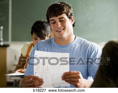 Student reading notes in a classroom. View Large Photo Image Stock Photo - Student reading notes in a classroom.. Fotosearch