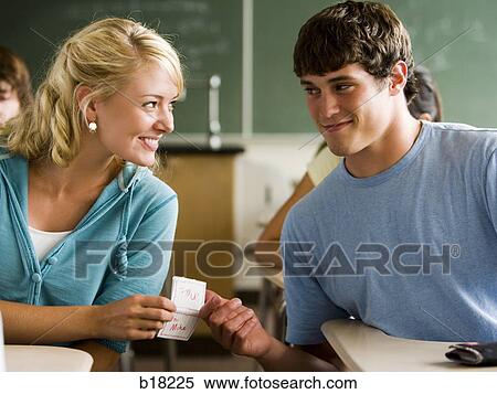 Stock Photography - Students passing notes in a classroom.. Fotosearch
