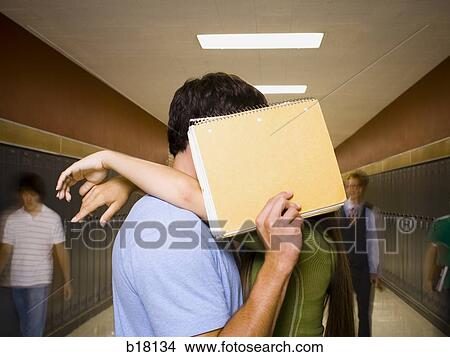 Picture - Teenage couple at school stealing a kiss.. Fotosearch