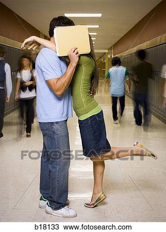 Stock Image - Teenage couple at school stealing a kiss.. Fotosearch