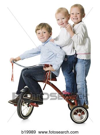 three children on a tricycle View Large Photo Image Stock Photo - three children on a tricycle. Fotosearch