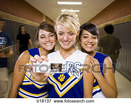 Three High School cheer leaders taking a picture with a mobile phone. View Large Photo Image Stock Photo - Three High School cheer leaders taking a picture with a mobile phone.. Fotosearch