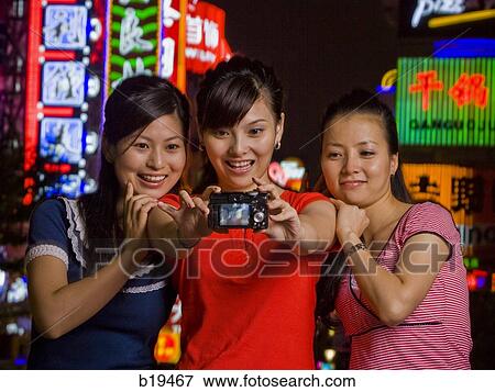 Stock Photo - three woman with a camera. Fotosearch