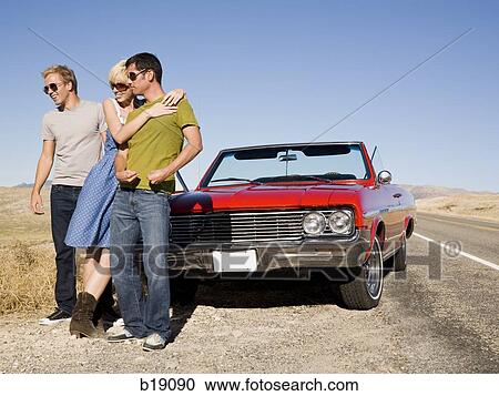 two men and a woman in front of a red convertible. View Large Photo Image Stock Image - two men and a woman in front of a red convertible.. Fotosearch
