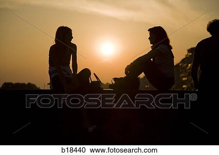 Two people talking at sunset. View Large Photo Image Stock Image - Two people talking at sunset.. Fotosearch