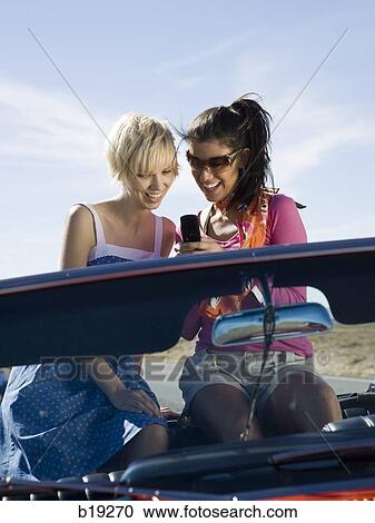 two women in a red convertible View Large Photo Image Stock Image - two women in a red convertible. Fotosearch