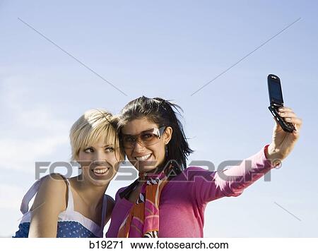 two women taking a photo View Large Photo Image Stock Image - two women taking a photo. Fotosearch
