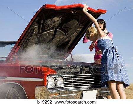 Stock Image - two women with a broken down car. Fotosearch