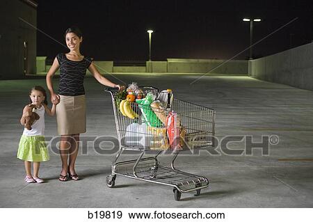 Stock Photo - woman and little girl with a shopping cart full of food. Fotosearch