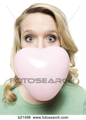 Stock Photo - woman blowing a heart shaped bubble. Fotosearch
