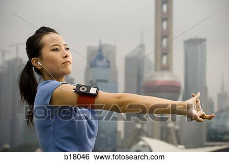 Woman exercising while listening to mp3 player. View Large Photo Image Stock Photograph - Woman exercising while listening to mp3 player.. Fotosearch