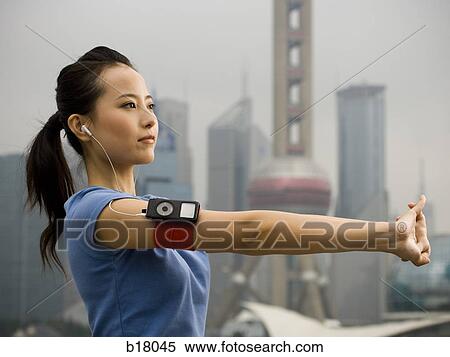 Stock Photography - Woman exercising while listening to mp3 player.. Fotosearch