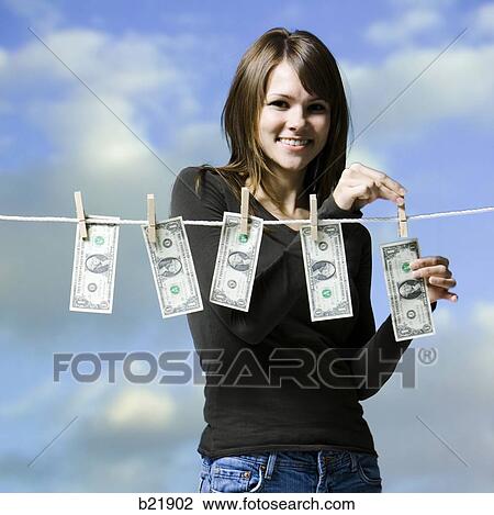 Stock Image - woman hanging money out to dry. Fotosearch