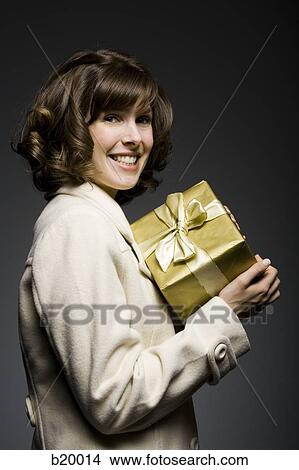 Picture - woman holding a gift. Fotosearch