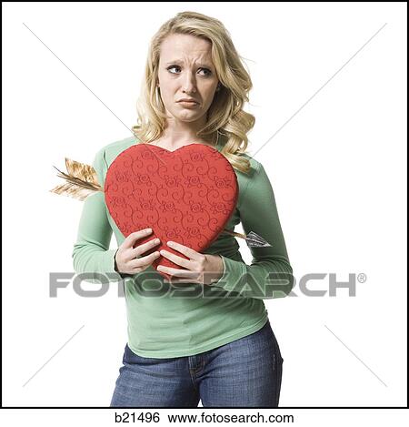 woman holding a heart with an arrow through it View Large Photo Image Stock Photograph - woman holding a heart with an arrow through it. Fotosearch