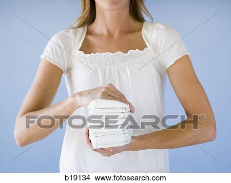 Woman holding a stack of diapers. View Large Photo Image Picture - Woman holding a stack of diapers.. Fotosearch