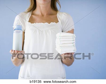 Woman holding diapers and a bottle. View Large Photo Image Stock Photography - Woman holding diapers and a bottle.. Fotosearch