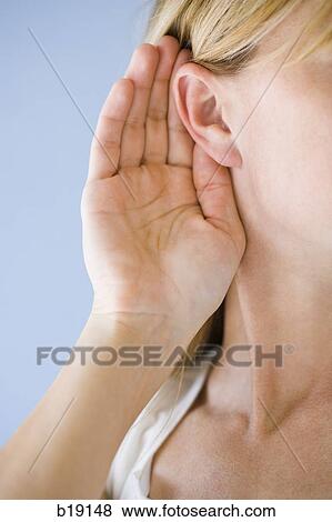 Stock Photo - woman holding hand to ear.. Fotosearch
