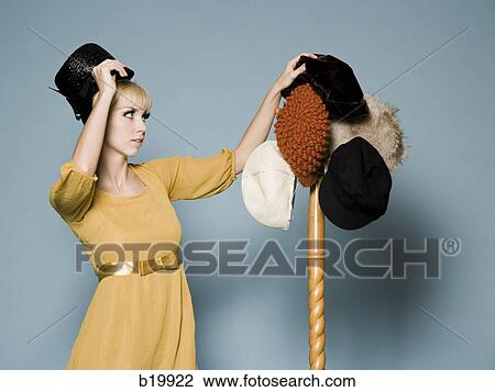 woman in 1960's attire trying on different hats View Large Photo Image Stock Image - woman in 1960's attire trying on different hats. Fotosearch