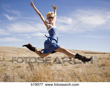 Stock Photo - "woman in the middle of nowhere, leaping in the air. ". Fotosearch