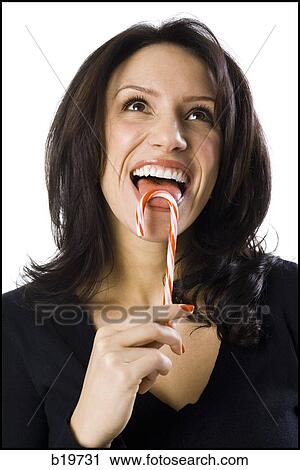 woman licking a candy cane View Large Photo Image Stock Image - woman licking a candy cane. Fotosearch