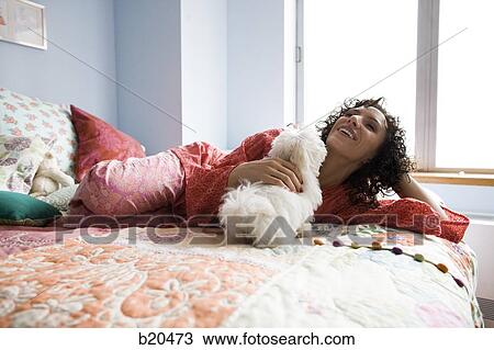 Stock Image - woman lying on a bed. Fotosearch