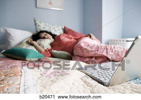 woman lying on a bed with a notebook computer View Large Photo Image Stock Image - woman lying on a bed with a notebook computer. Fotosearch
