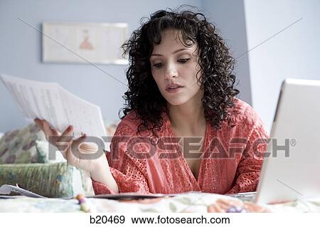 woman lying on a bed with a notebook computer View Large Photo Image Stock Photo - woman lying on a bed with a notebook computer. Fotosearch