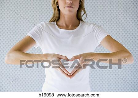 Stock Photo - Woman making a heart shape with her hands.. Fotosearch
