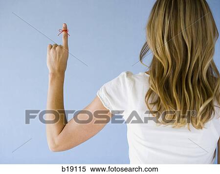 Stock Photography - Woman with a red string tied on her finger.. Fotosearch