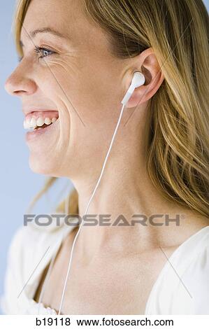 Stock Photo - woman with earphones in her ears.. Fotosearch