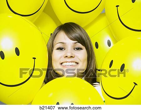 Stock Photo - woman with smiley face balloons. Fotosearch