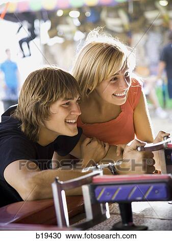 Stock Image - young couple at an amusement park. Fotosearch