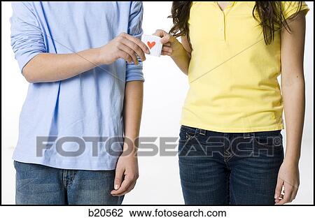 Stock Image - young couple passing a note. Fotosearch