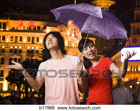 Young couple under an umbrella. View Large Photo Image Stock Photograph - Young couple under an umbrella.. Fotosearch