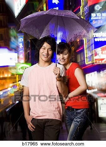Young couple under an umbrella. View Large Photo Image Stock Photography - Young couple under an umbrella.. Fotosearch