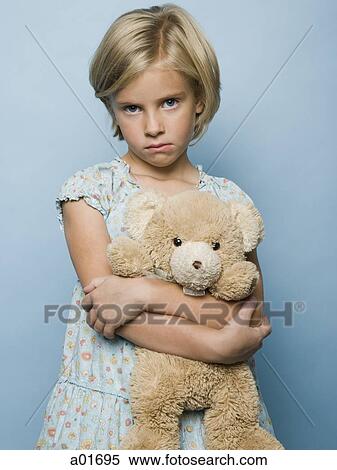 Young girl holding a teddy bear and frowning. View Large Photo Image Stock Photography - Young girl holding a teddy bear and frowning.. Fotosearch