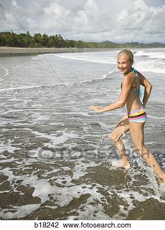 Young girl running in the surf. View Large Photo Image Stock Image - Young girl running in the surf.. Fotosearch