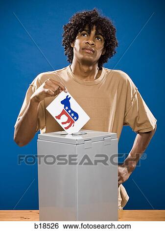 young man in a brown shirt casting a ballot. View Large Photo Image Stock Photograph - young man in a brown shirt casting a ballot.. Fotosearch