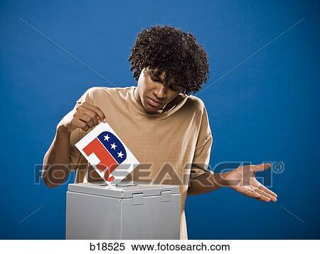 Stock Photography - young man in a brown shirt casting a ballot.. Fotosearch