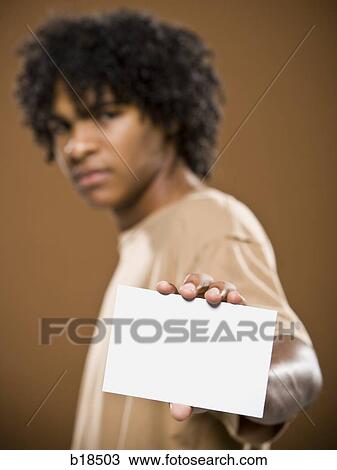 young man in a brown shirt holding a note card. View Large Photo Image Stock Image - young man in a brown shirt holding a note card.. Fotosearch
