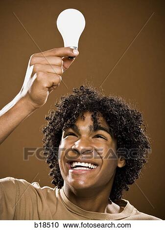 young man in a brown shirt holding light bulbs. View Large Photo Image Stock Image - young man in a brown shirt holding light bulbs.. Fotosearch