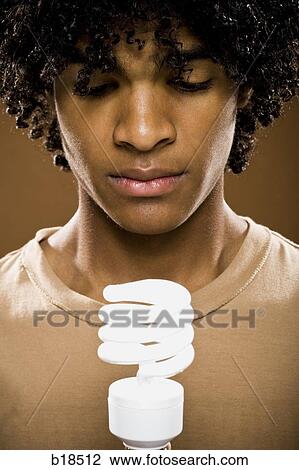 young man in a brown shirt holding light bulbs. View Large Photo Image Stock Image - young man in a brown shirt holding light bulbs.. Fotosearch